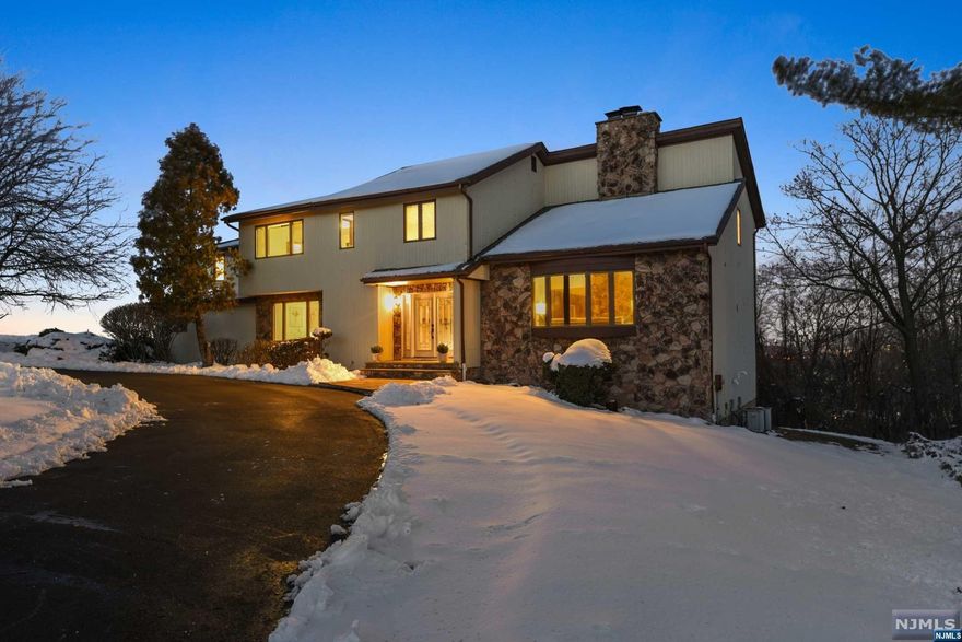 Custom contemporary is set on 1.1 acres (one of larger lots in Park Ridge Estates) on a serene cul-de-sac. 2-story entry foyer flows to LR on one side & formal DR on the other. LR w/ soaring ceiling & natural stone FP that wraps around to Fam Rm. Sliders open to deck w/ panoramic views of valley below & seasonal views of NYC. Kitchen adjacent to Fam Rm also w/ sliders to deck, features marble flr, breakfast bar & central island. Mudrm & laundry off kitchen opens to garage & side entry. Central staircase leads to 2nd floor balcony. 3 bedrooms & full bath on this level, plus spacious Primary Suite w/dressing rm, 2 walk-in closets & bathroom -- also has deck facing east. Lower level recently renovated -- a huge space w/ high ceilings & fireplace. It can be easily turned into a rec room, exercise studio, or media room, etc. In addition, this level includes a spacious 5th BR & full bath. Sliders access the back patio & wooded yard. NYC bus stop at the corner.