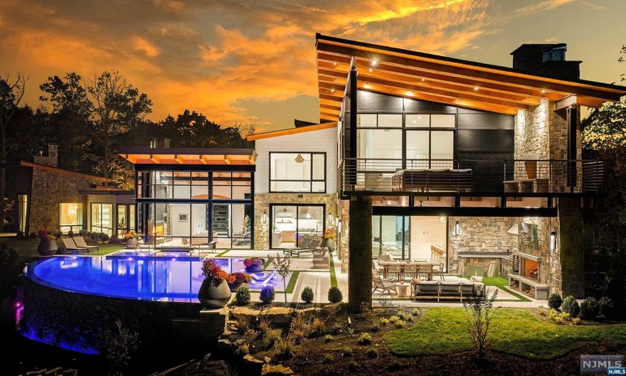 An Aspen, Colorado home on the East Coast? This Modern Day Glasshouse designed by Colorado-based firm, Berglund Architects, sits on an 8-acre private peninsula surrounded by water. Located in the Prestigious Smoke Rise community just 35 minutes from NYC, your serene & peaceful escape awaits. This Private Peninsula Estate features 10,321 square feet of finished living space including 6 bedrooms (2 primary suites), 9 baths, a finished basement lounge, and an 8-car garage with plenty of room for all your off-roading toys. The minute you walk in the front door you will be captivated by floor-to-ceiling windows overlooking a setting that cannot be duplicated. A world-class infiniti pool & spa overlooking Lake Kinnelon, an incredible full outdoor kitchen and fireplace, & a designer tailor-made bar drum-up the most tranquil outdoor backdrop you will ever see. Built in 2022 with a vision in mind for years to come!