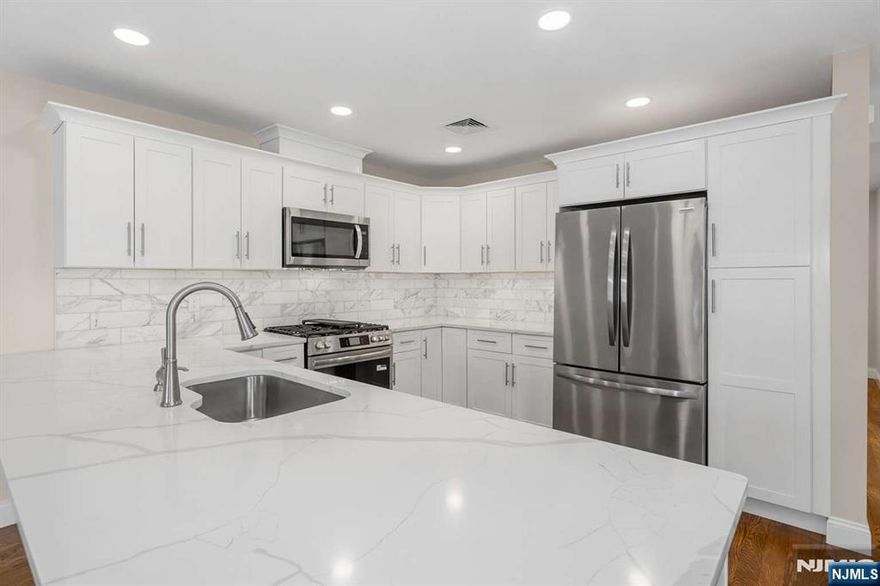 No monthly HOA fee, newer construction, private fenced yard larger than most townhomes offer, and a walkable train commute to NYC, an extremely rare combination. Move-in ready, this 4 bedroom, 3.5 bath home offers approximately 2,300 sq ft of modern living space, garage parking, a two car driveway, and additional street parking. The main level features an open concept layout with a chefâ€™s kitchen, brand new quartz countertops, stainless steel appliances, dining area, spacious living room, and half bath. Upstairs offers three bedrooms and two full baths, including a primary suite with walk in closet and en suite bath. Ground level includes a fourth bedroom, full bath, and garage access. Located on a quiet non through street just steps from shops, restaurants, parks, and everyday conveniences, with an easy walk to the train for commuting to NYC. Located in highly rated Waldwick with top rated schools, surrounded by Bergen County favorites including Ridgewood, Ho Ho Kus, Allendale, and Saddle River. Minutes to downtown Ridgewood, Whole Foods, premier shopping, dining, and major malls. Rare opportunity to own a low maintenance newer home with privacy, outdoor space, and commuter convenience in one of Bergen Countyâ€™s most desirable locations.
