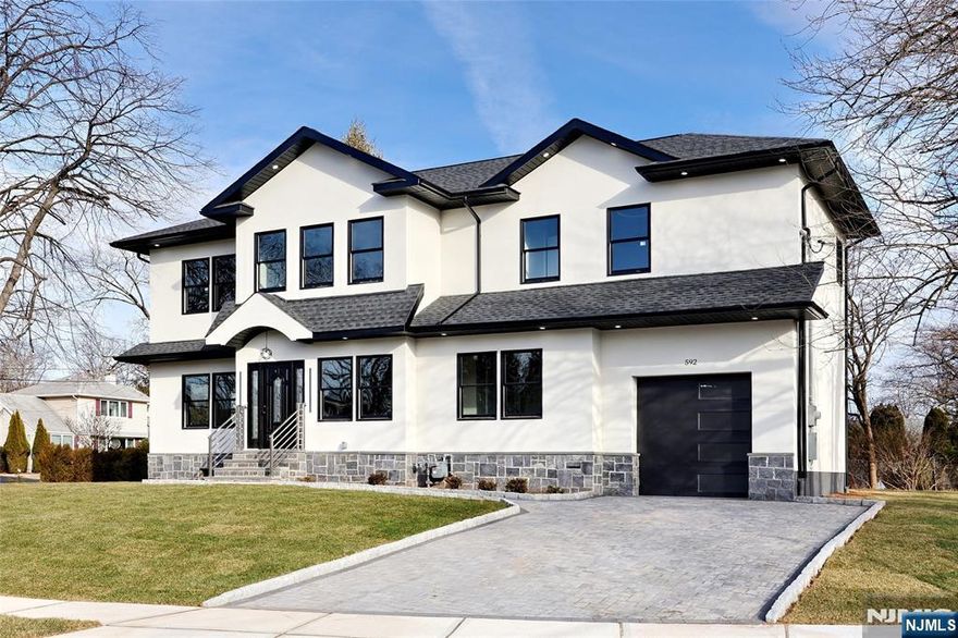 Modern 5-bedroom, 5.5-bath custom home in a prime New Milford location, offering exceptional space, design, and versatility. Featuring two primary suites and a fully finished oversized basement, this home is ideal for extended living, entertaining, or work-from-home flexibility. The open-concept layout showcases a sleek kitchen with stainless steel appliances, built-in microwave, and crisp white countertops, flowing seamlessly into spacious living and dining areas filled with natural light. Built with quality in mind, the home includes Andersen windows and doors, 2-zone central HVAC, and a durable exterior of stucco over Hardie cement board with natural stone accents. Situated on a quiet residential street close to schools, shopping, and major highways, this property offers both comfort and convenience.