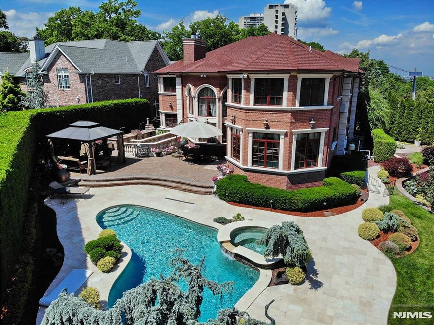 Rare opportunity for the most discerning buyer to reside on an exclusive cul-de-sac of the sought after Bluff section in Fort Lee. This spectacular all brick Central Hall Colonial is very private and spreads on meticulously manicured grounds with a resort-like amenities: an in-ground heated Gunite pool with waterfall tiled with Mozambique stones, jacuzzi, CABANA & BBQ area . Unmatched in every aspect it features 6 bedrooms, 6.5 baths, high ceilings, hardwood floors, radiant heat, sauna, gym, movie theater & smart home features. Located within walking distance to shopping, restaurants, schools and the house of worship. NYC bus stop and free ferry bus right at the doorsteps