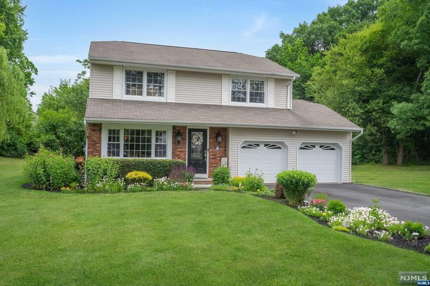 This immaculate 4 bedroom/2.5 bath colonial, lovingly updated over the years with gorgeous perennials and landscaping will "WOW" you! Located on a lovely flat lot, close to schools, you are greeted by a decorated glass door that leads to a tiled hallway open to a sun filled LR. It has hw floors, crown molding and a large triple pane front window. Crown molding and glistening hw floors are also to be found in the adjacent room, located next to the large kitchen. The powder rm and laundry rm with access to the oversize 2-car garage are located off the kitchen. The cozy FR offers a w/b fireplace in a brick surround, a vaulted ceiling, carpeted floor and a glass door to the fabulous outside patio. The staircase takes you to a spacious landing from which you will enter 3 pristine bedrooms, a renovated full hallway bath plus a spacious primary suite with 2 closets and a full bathroom with a shower. All bedrooms offer hw floors. The finished basement completes this exquisite home!