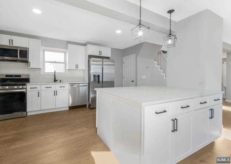 This home is 4 bedrooms, 2 full baths and 1 half bath. It is a beautiful 3 bed, 1 full bath, 1 half bath in the front with a gorgeous in law suite in the back with 1 master bedroom and one full bath. This home received extensive renovations down to the studs, the house has updated mechanicals including a 200 amp electric panel, new water heater, forced hot air unit, new condenser for HVAC, new mini split air-conditioners in each room for separate room temperature control for everyone's comfort. It has a gigantic living room and kitchen space that was extended for the home Owners to use the maximum space of this homes 1st floor. New kitchen with new cabinetry, beautiful Carrera quartz throughout including the in law kitchen space, new flooring and new high end stainless steel appliances. Get the feeling of new construction but only pay a fraction of the price, located in a quite street with terrific school system, parks, restaurants and proximity to NYC.