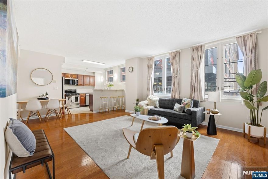 Finding a home in Downtown Jersey City often means choosing between vibrant city living and residential comfort, but Unit 1A at 143 Morgan Street offers both. Located in the sought-after Powerhouse Arts District, this rare corner residence features oversized windows and a bright, open layout that creates a warm and inviting space. The kitchen is the heart of the home, with cherry cabinetry, granite countertops, and stainless-steel appliances that flow seamlessly into the main living area, all complemented by classic hardwood floors. What truly sets this home apart are features rarely found together in this neighborhood. Along with the convenience of in-unit laundry, the residence offers a massive private outdoor patio, perfect for relaxing or entertaining. Even more exceptional is the inclusion of two deeded parking spaces, a rare luxury in this prime location. The building has also seen major recent upgrades, including a brand-new façade and new windows completed in January 2025, improving both efficiency and curb appeal. A private backdoor access to Steuben Street places you just one block from the PATH, providing an easy commute to Manhattan or Hoboken. Surrounded by waterfront parks, local galleries, and top restaurants and cafés, this home offers the perfect blend of comfort, convenience, and city living.