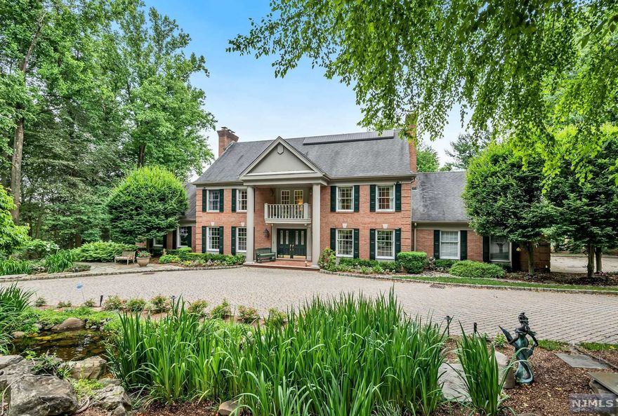 Welcome to this Classic Georgian-Style Brick Colonial, tucked away on 2 acres of stunning property on desirable Powder Hill Road. Peaceful water features and lush plantings greet you at your front door. Large deck spans back of home, overlooking pool and pristine backyard. Inside, traditional layout with spacious rooms, impressive foyer, hardwood floors, millwork, custom built-ins, four fireplaces and updated kitchen open to fabulous vaulted-ceiling great room. Second floor has Primary suite with fireplace and three additional bedrooms. Lower level is finished with over 1500+ square ft, including large rec room, media room with bar, powder room and walk out access to pool. Truly your our own private oasis in Saddle River. Classic Elegance awaits you at 13 Powder Hill Road.