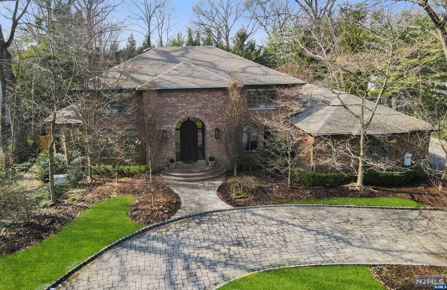 NO FURTHER SHOWINGS. Nestled on one of Tenafly's most coveted streets this East Hill CHC brick estate is an impressive home. The grand 2-story EF greets you w/a sweeping staircase. A seamless 1st flr flow; LR adorned w/windows bathing the rm in natural light flows into a spacious great room, w/coffered ceiling, stone fplc & wall of windows. Open to the GRT RM a recently ren EIK w/high-end appl incl a 60" gas Wolf range & steam oven. Adjacent, the formal DR, cherry-paneled office & full bth offer functionality for today's discerning buyers. The 2nd lvl boasts a lux primary BR suite w/tray ceiling mrbl fplc, 2 WIC's & ren primary bth w/heated flrs. 3 addl BRs, along w/2 ren full bthrms, ensure comfort for the family. The LL redefines entertainment, boasting a full KIT, media space, gym & plenty of rec space for a fun time. A staycation BKYD fts a heated pool & hot tub surrounded by privacy trees. The outfitted 3-car garage is the deal closer.