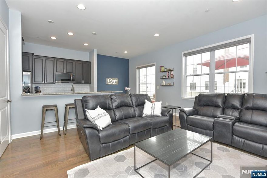 Discover this stunning, sunlit 4-bedroom, 3.5 bath townhouse in the sought-after Wright Place at Wesmont Station. Spanning over 2,200 sq ft, this beautifully appointed New Jersey model features luxurious finishes across three levels, including hardwood floors, recessed lighting, and soaring ceilings. The first floor offers a welcoming entry foyer, versatile bedroom/home office, full bath, a rear hallway with ample closets and a two-car attached garageâ€”perfect for daily living. The second level showcases an open-concept living room and a gourmet kitchen with upgraded appliances, quartz countertops, custom cabinetry, a breakfast bar, pantry, and a convenient butlerâ€™s pantry with wine fridge. Adjacent to the kitchen, you'll find a dedicated dining area that opens to a lovely outdoor deck, ideal for entertaining. A separate playroom/dining room provides additional versatile space. Upstairs, the primary suite features an ensuite bath and two walk-in closets, complemented by two additional bedrooms, a full bath, and laundry area. There are many amenities, including hardwood flooring, custom remote-controlled roller shades, multi-zone heating and AC with learning Nest thermostats, a Simplisafe system, and more. Ideally situated near NJ Transit, local shopping, and the town recreation facilities, this exceptional home combines style, comfort, and prime accessibility. Schedule your private tour today!