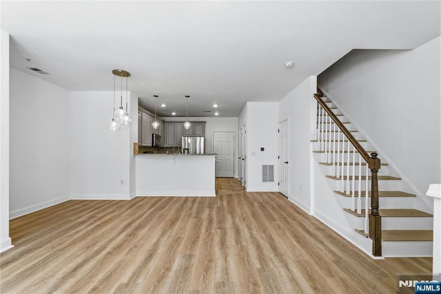 Call Charmy Morzaria at 609.619.2198 to tour. Welcome to this beautifully upgraded, move-in-ready, Sun Filled End-unit townhome in Liberty Square at Wesmont Station, offering beautiful upgrades and modern improvements. Step inside to discover a bright and spacious open-concept layout designed for today's lifestyle. Tall windows bringing in tons of daylight, beautiful flooring flows throughout the main level, complementing the stylish kitchen featuring custom cabinetry, designer backsplash, upgraded fixtures, a pantry, and stainless steel appliances. The first floor also offers a dining area with a full bath, a sun-drenched living room perfect for entertaining, and convenient access to the attached one-car garage (w/Universal EV charger) & private driveway offering two private parking spaces. Upstairs, retreat to an impressive primary suite complete with a spa-inspired bath showcasing a soaking tub, separate shower stall, and generous dual walk-in closets. This level is thoughtfully completed with a well-sized guest bedroom, an additional full bath, and a dedicated laundry & utility room for added convenience. Enjoy the added benefit of being next to the parks, just steps from your door, enhancing both lifestyle and value. Ideally located near NJ Transit train and bus service, coffee shops, grocery stores, shopping centers, and major highways, this home offers exceptional convenience for both New York and New Jersey commuters.A perfect blend of comfort, style, and location.