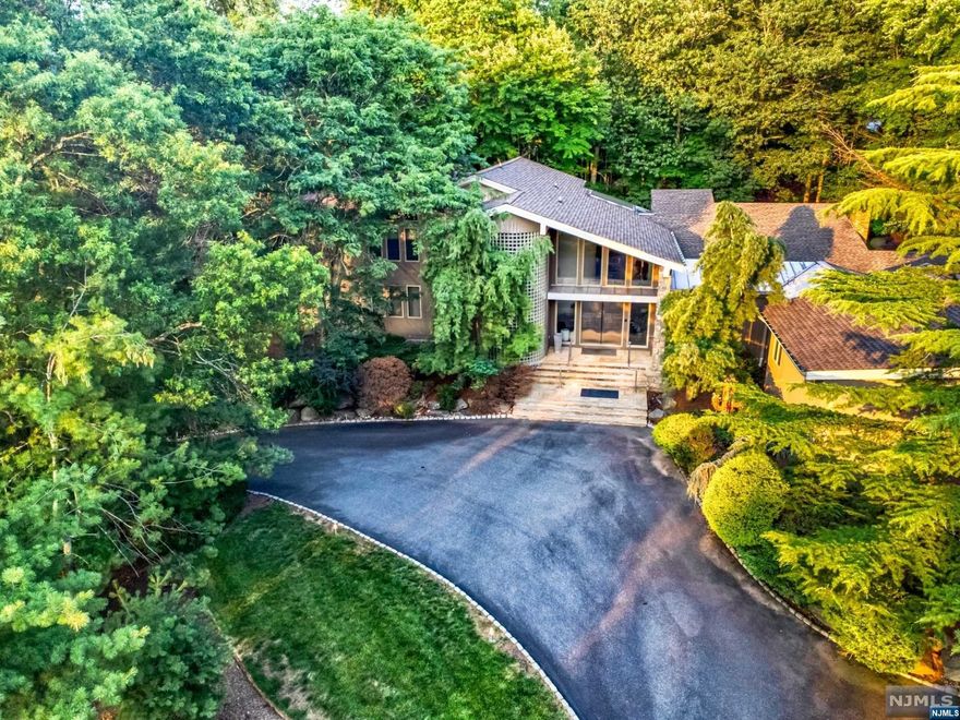 Welcome to this beautiful and expansive home located in Livingston's premiere neighborhood of Chestnut Hill. With a rarely seen modern architectural style welcoming you as you enter with soaring ceilings and clean lines, this 7,700 sq foot home has 5 bedrooms, including a massive private master suite, and 9 bathrooms total. This striking home is nestled on .89 acres and set back, with lush landscaping bringing a peaceful sense of privacy, and with a soft-water filtered pool tucked in the back. Complete with a pool cabana room with a shower and powder room, as well as a home theatre room, a chef's kitchen, and fully finished basement - this property's style is very unique, while keeping an extremely sensible layout and a welcoming ambience. Contact Athos - (646) 549-9439 for video walkthrough link