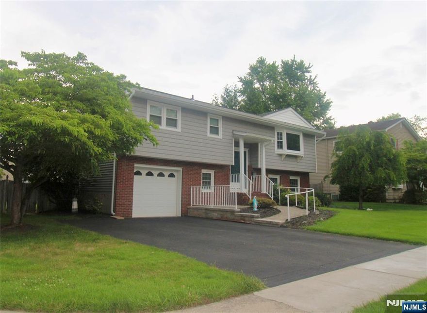 The spacious Corner Lot Bi-level nestled on corner lot. It boasts 4 spacious bedrooms, 1.5 baths. Central Air Hardwood floors throughout. Newer Hot Water heater, furnace and roof. Well cared for as you can see by the beautiful curb appeal. Sliders leading to private yard and patio for relaxing and entertaining. 1 Car garage. Close to all major highways, park, tennis, shopping and NY transportation.