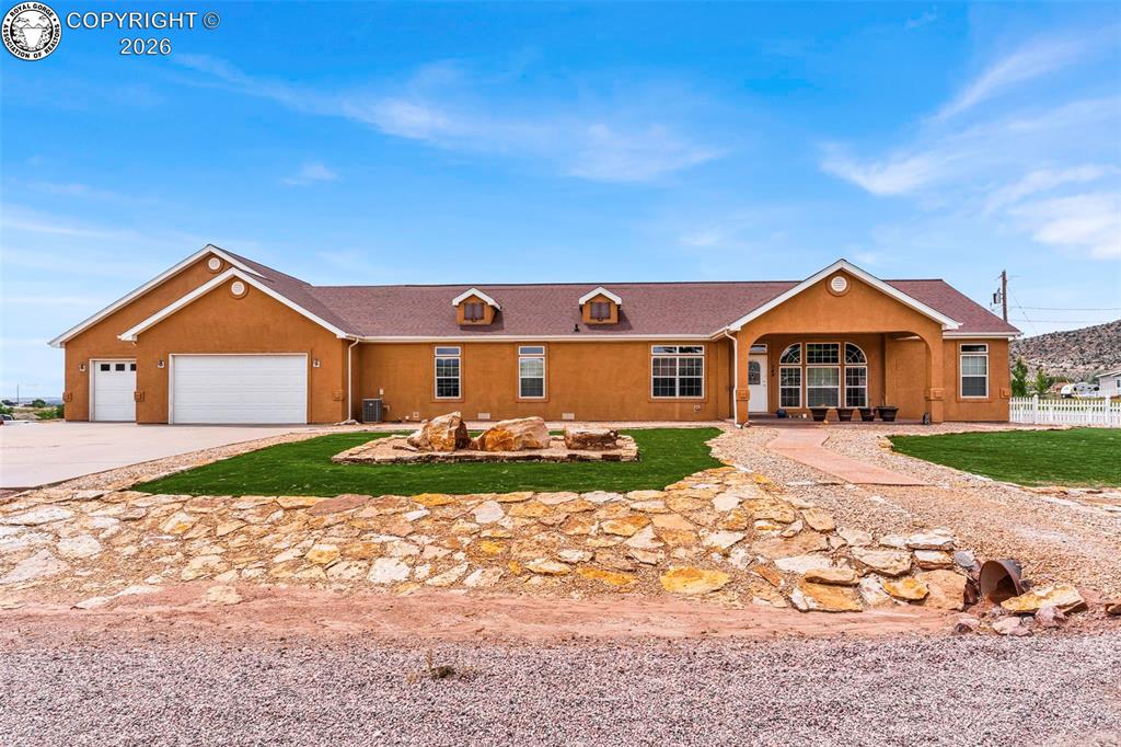 Stucco exterior with a covered entry, multiple dormer windows, and an attached three-car garage