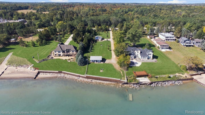 Expansive waterfront property featuring two residences, substantial green space, and a private boat lift