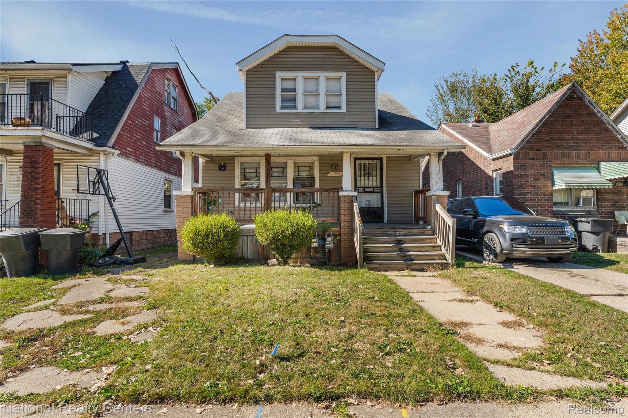 View of front of home featuring a front yard, a porch, and a shingled roof