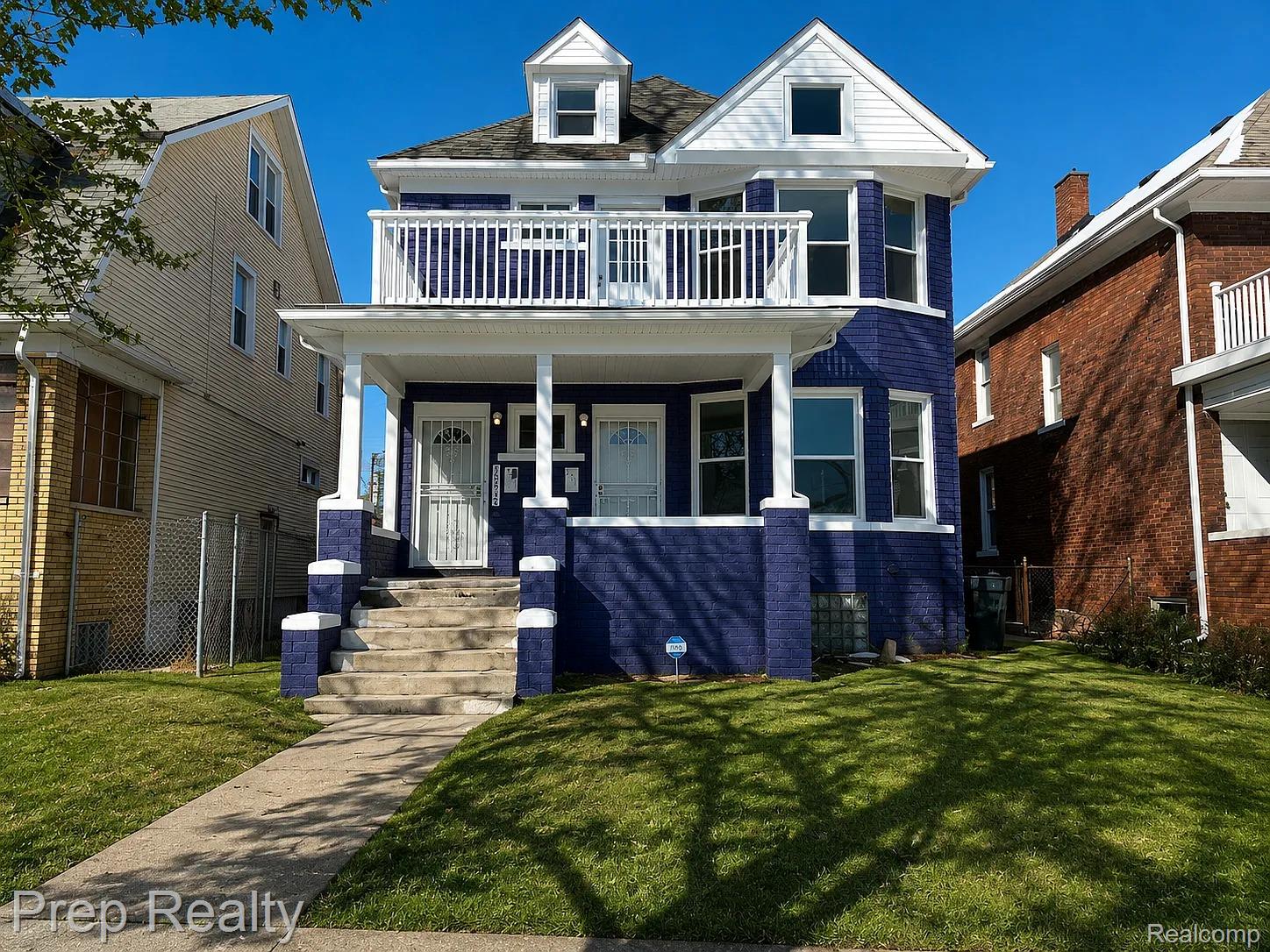 Two-story brick facade residence with a vibrant blue finish