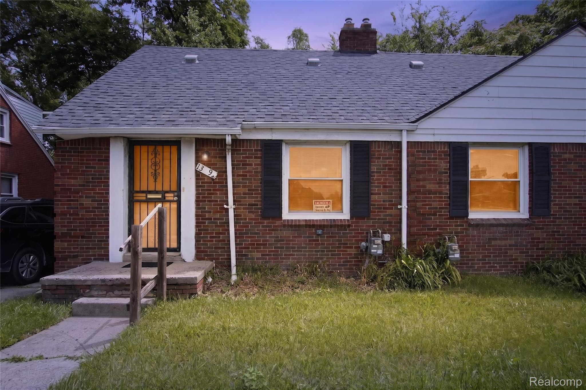 Brick exterior with white siding accents and a gray shingled roof