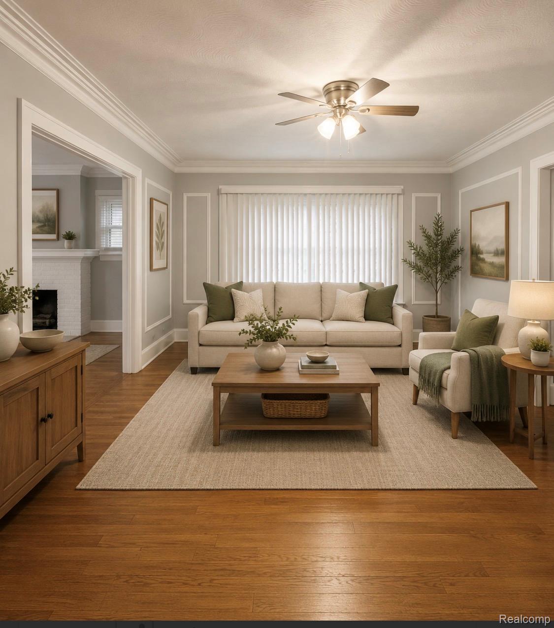 Formal living room featuring wood-finish flooring, crown molding, and wainscoting details
