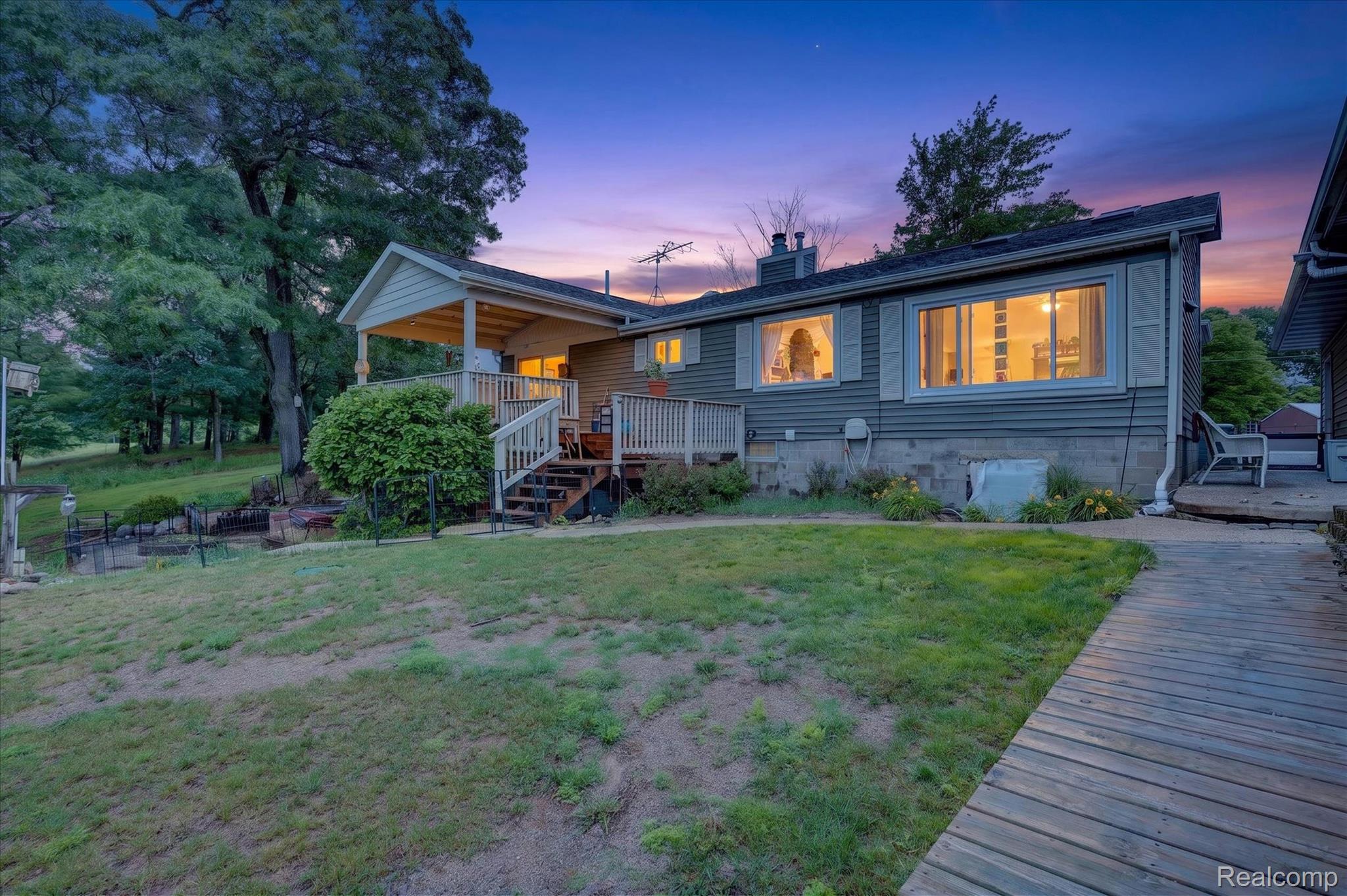 Rear exterior featuring a covered porch, a multi-level deck, and a wooden walkway