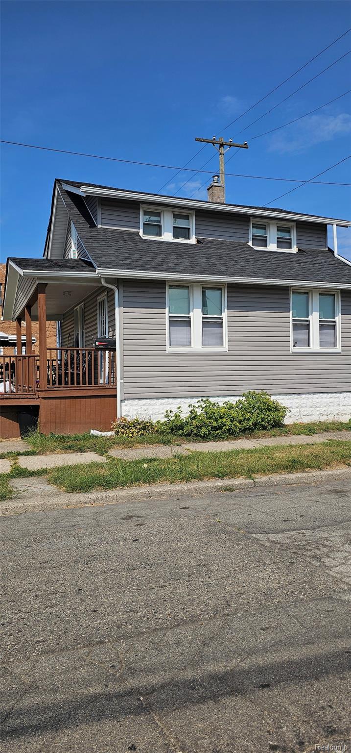 View of home's exterior featuring a porch and a chimney