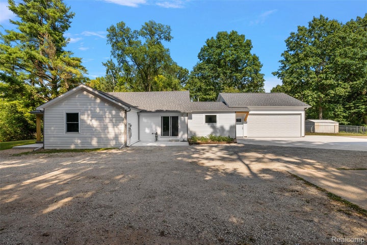 Single story home featuring concrete driveway, an attached garage, and a shingled roof
