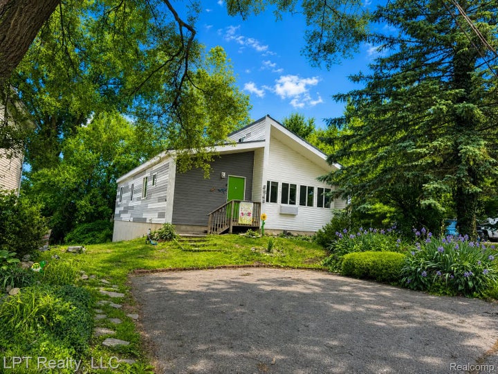 Contemporary-style exterior with a gabled roof and a vibrant green entry door
