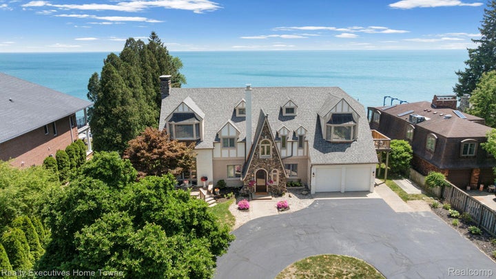 Stone and stucco exterior featuring multiple gables and a two-car garage
