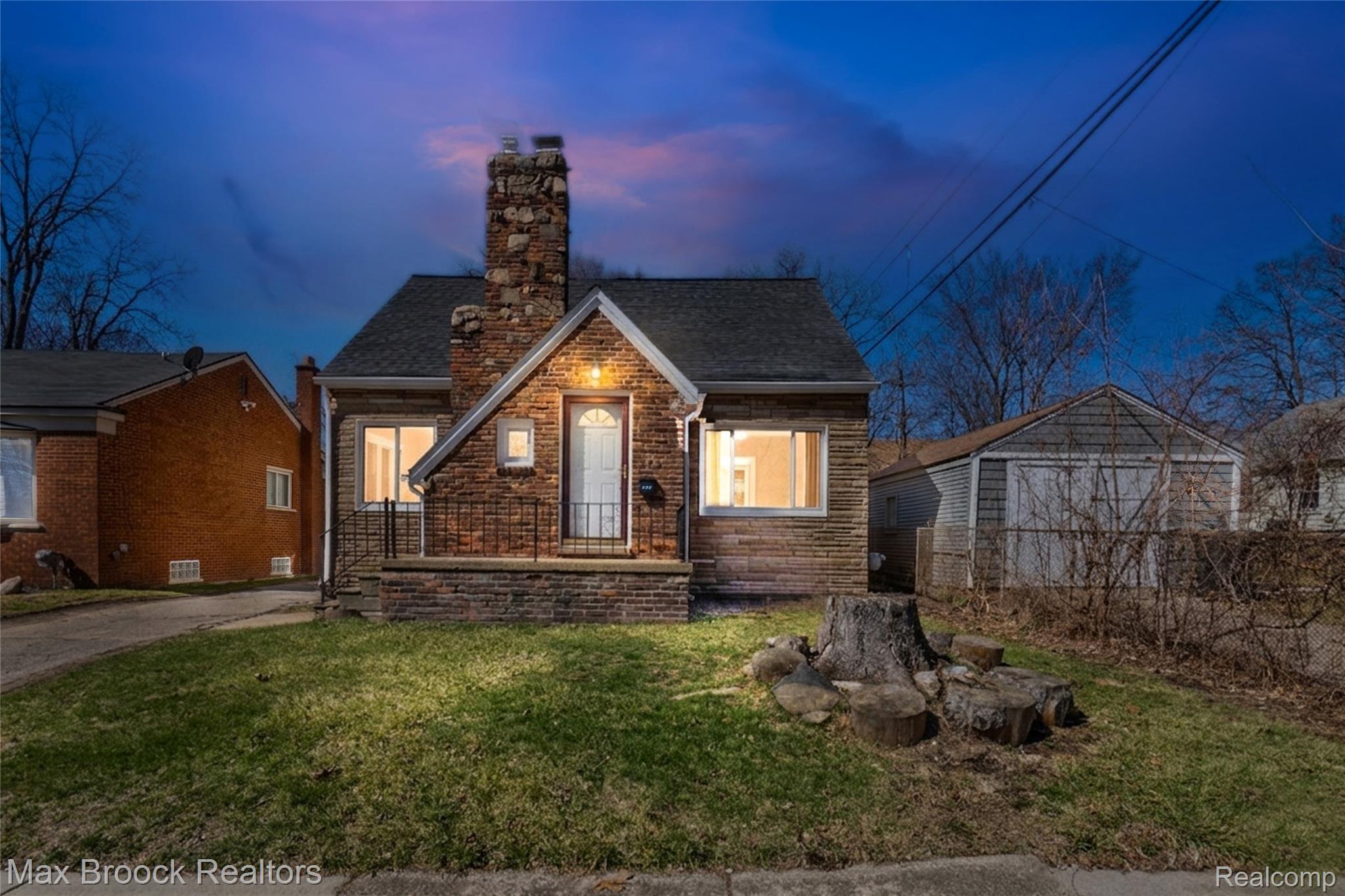 View of front of house with a chimney, a shingled roof, and stone siding