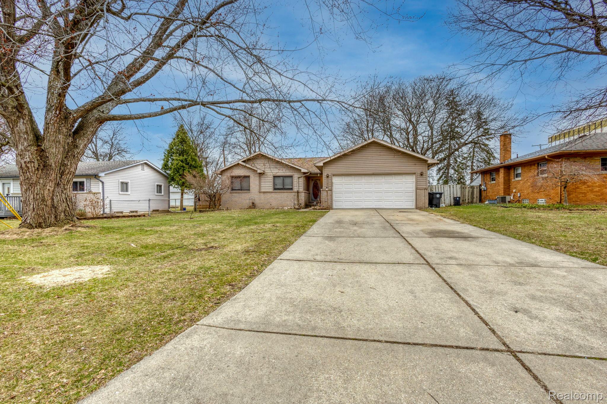 View of front of property featuring driveway, an attached garage, and a residential view