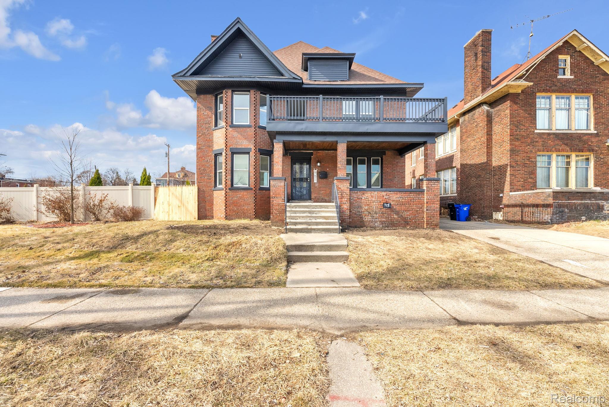 View of front of property featuring brick siding, a porch, and a balcony