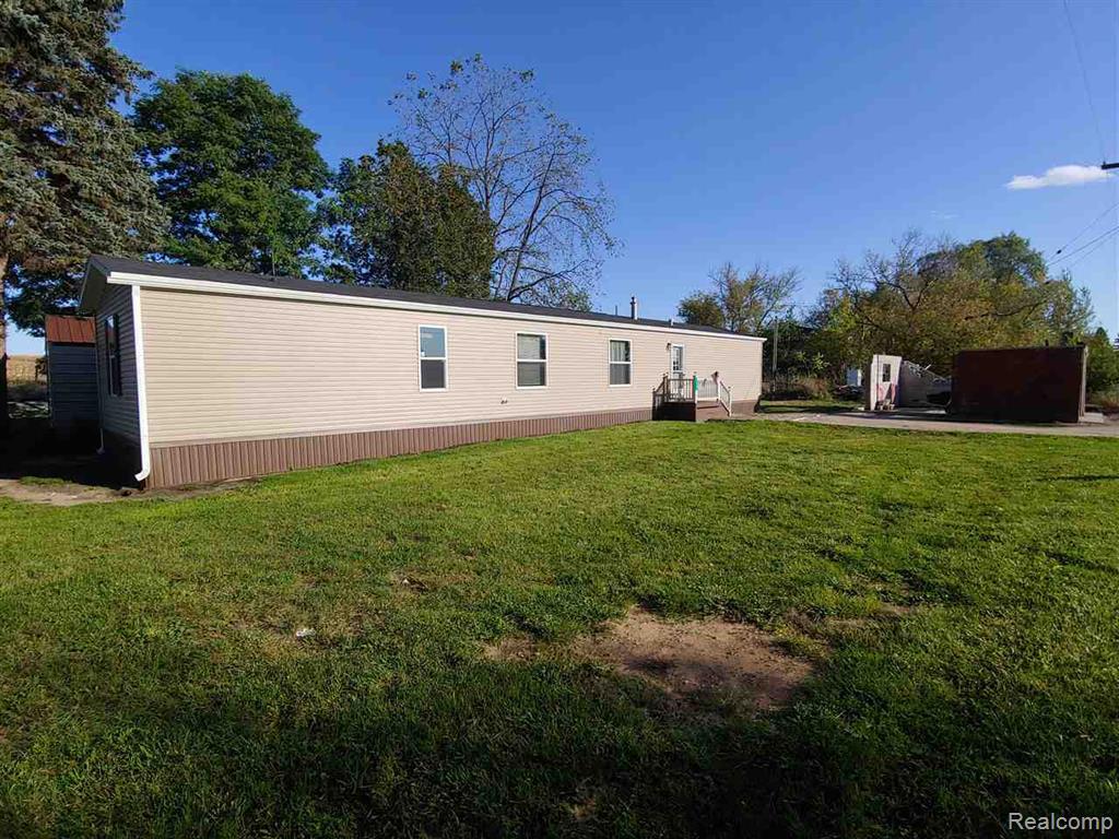 Back of house with a yard