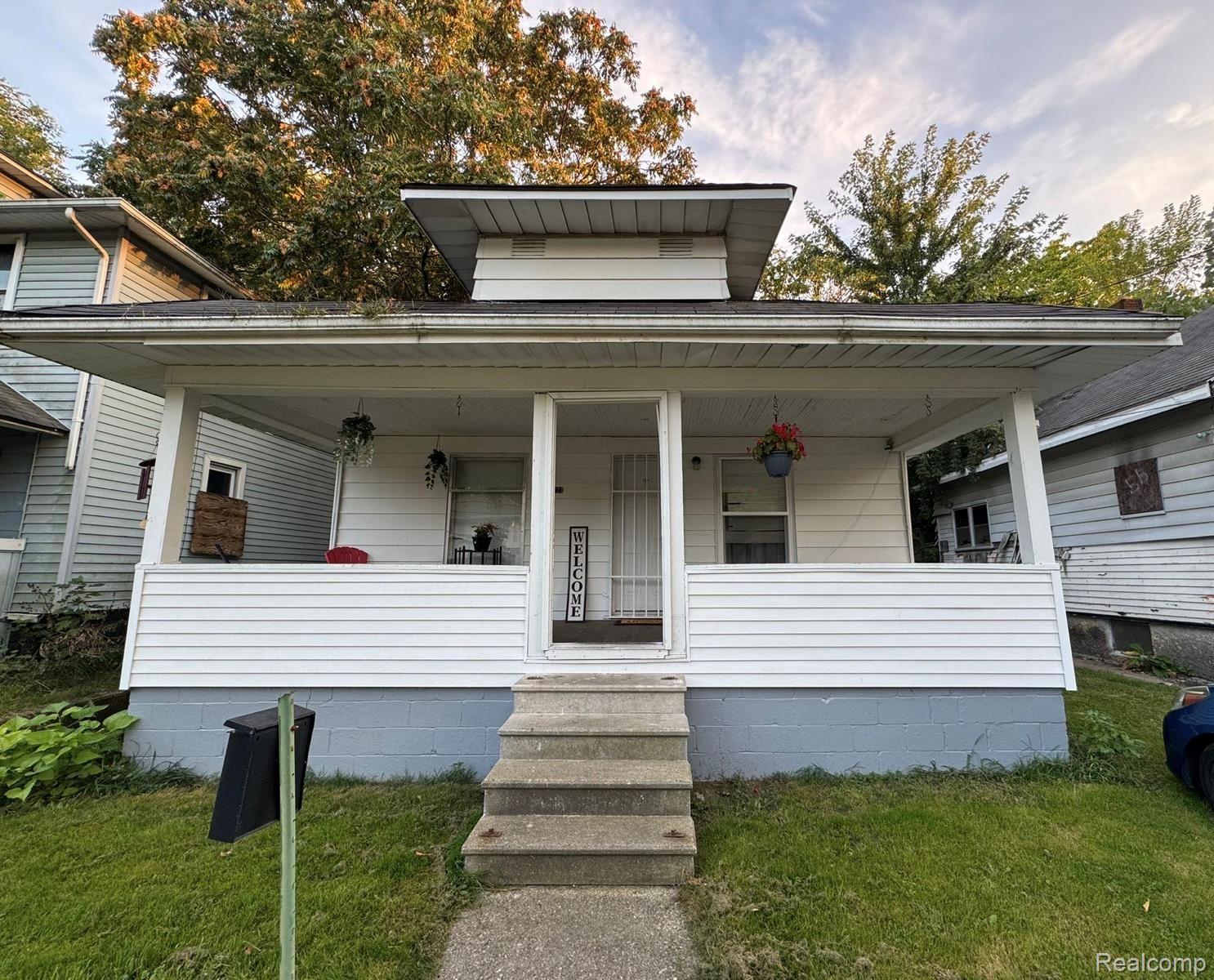 View of front of home featuring a front yard and a porch