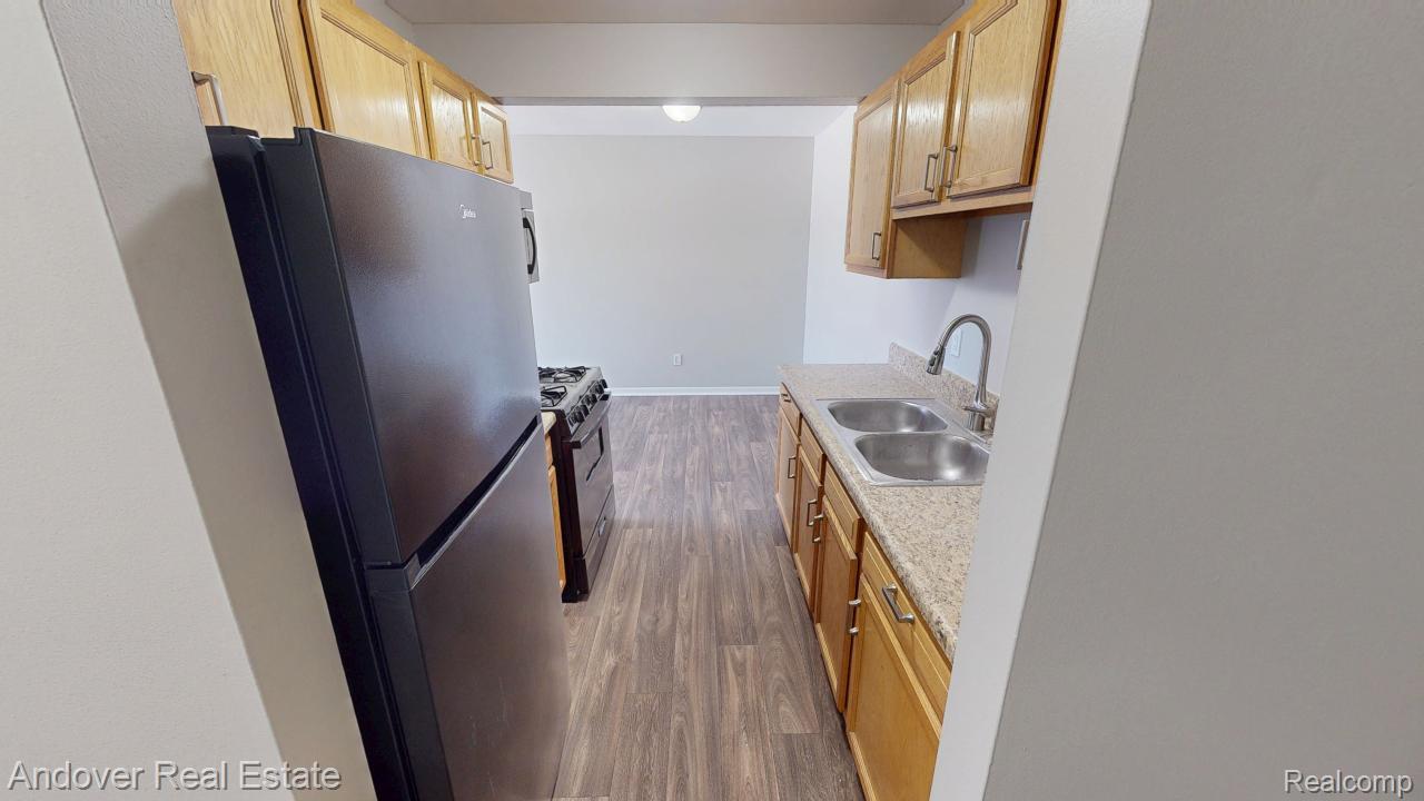 Kitchen with freestanding refrigerator, dark wood finished floors, and black gas stove