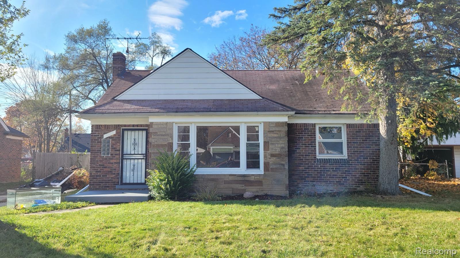 Bungalow featuring a chimney and stone siding