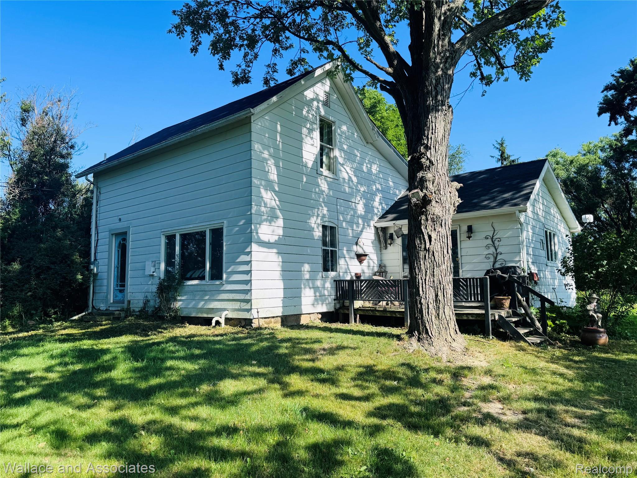White siding exterior featuring multiple windows and a black roof