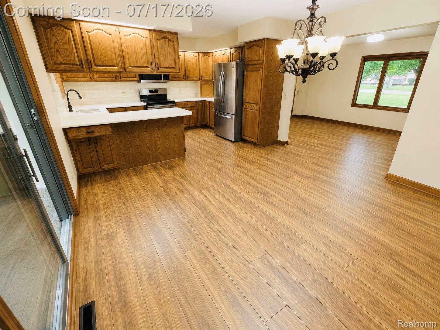 Open-concept kitchen and living area featuring wood-finish flooring