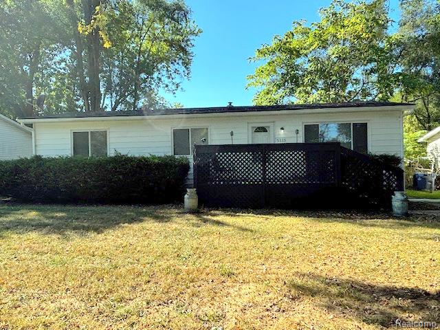 Back of house with a yard and a deck