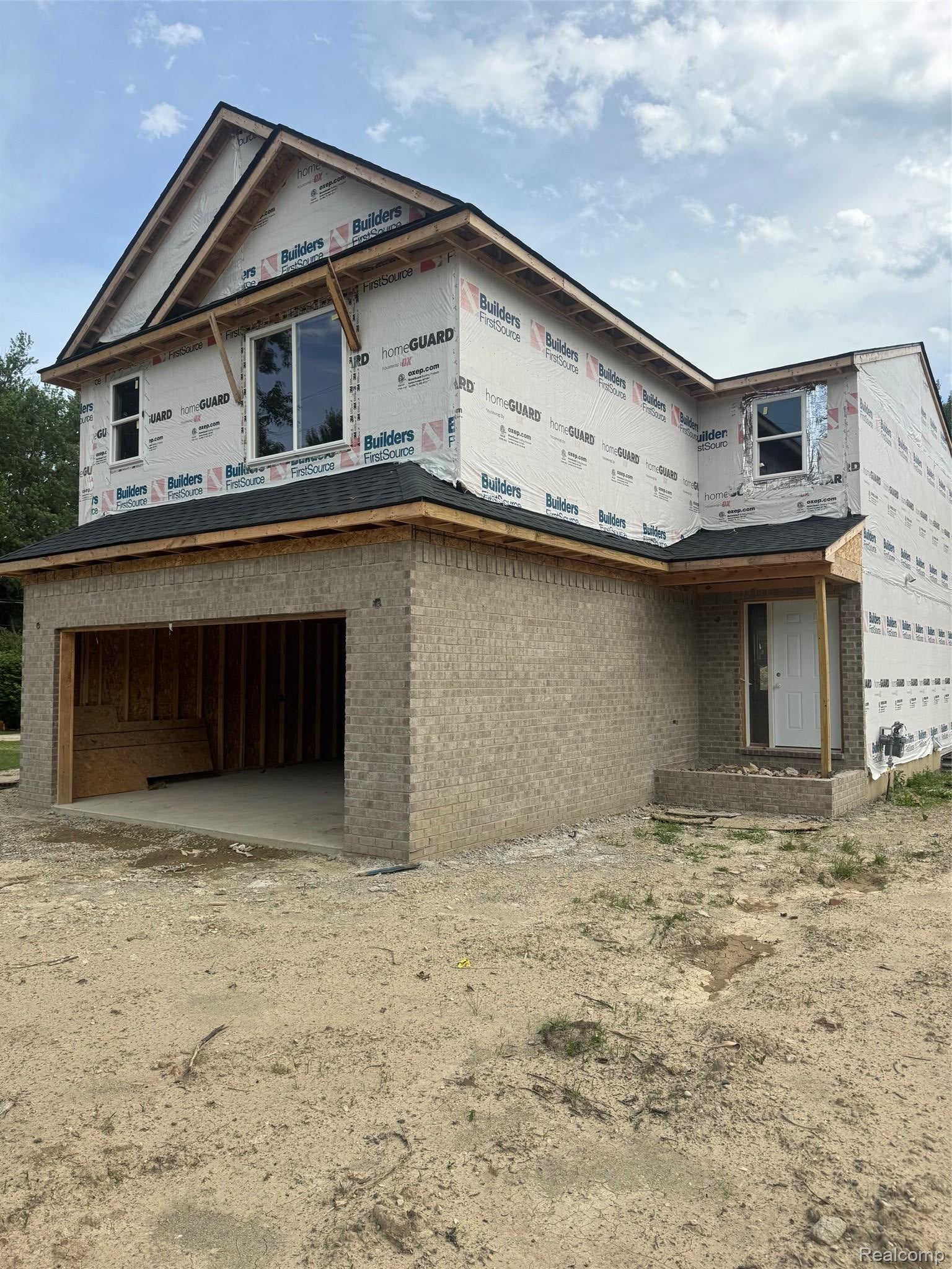 Traditional-style home featuring brick siding, a garage, and concrete driveway