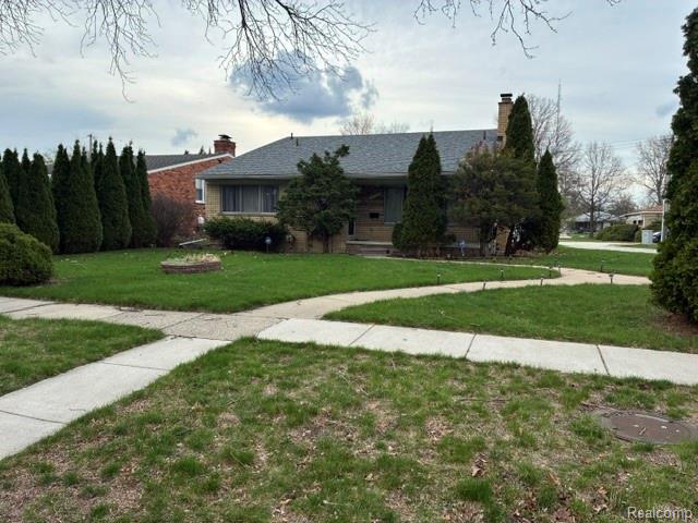 View of front of house with a chimney and a front yard