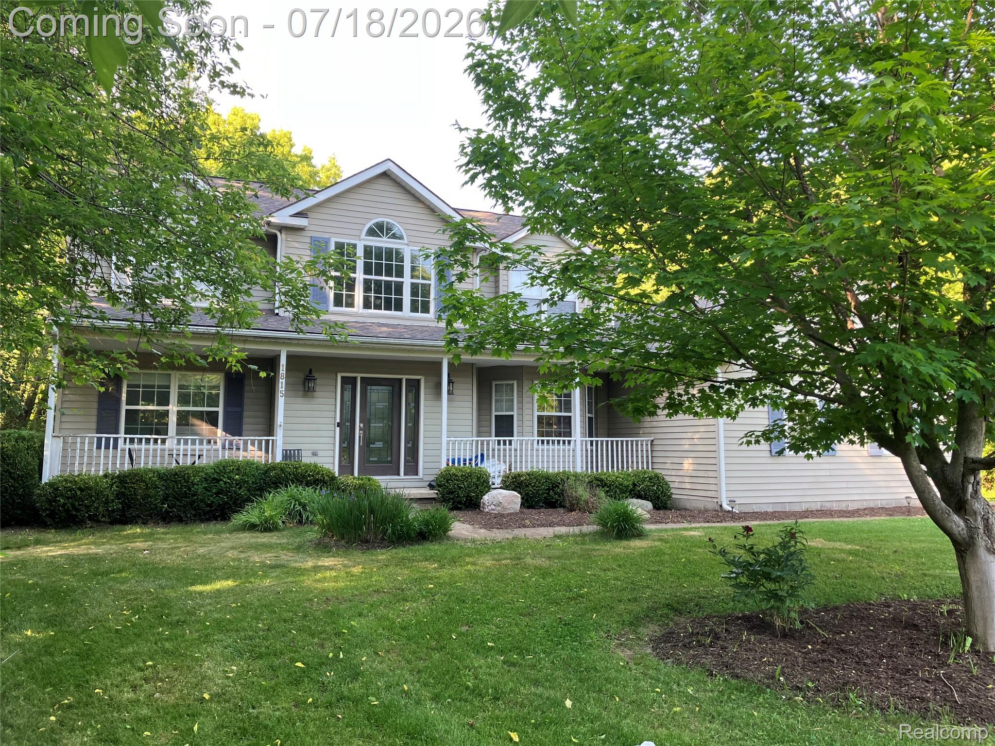 Traditional-style residence featuring light-colored siding and dark shutters