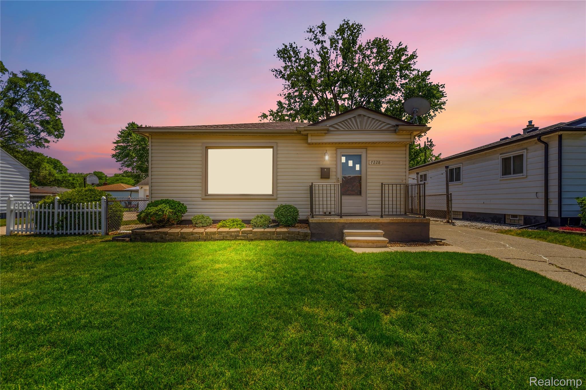 Ranch-style exterior with beige siding and a prominent front porch with metal railings