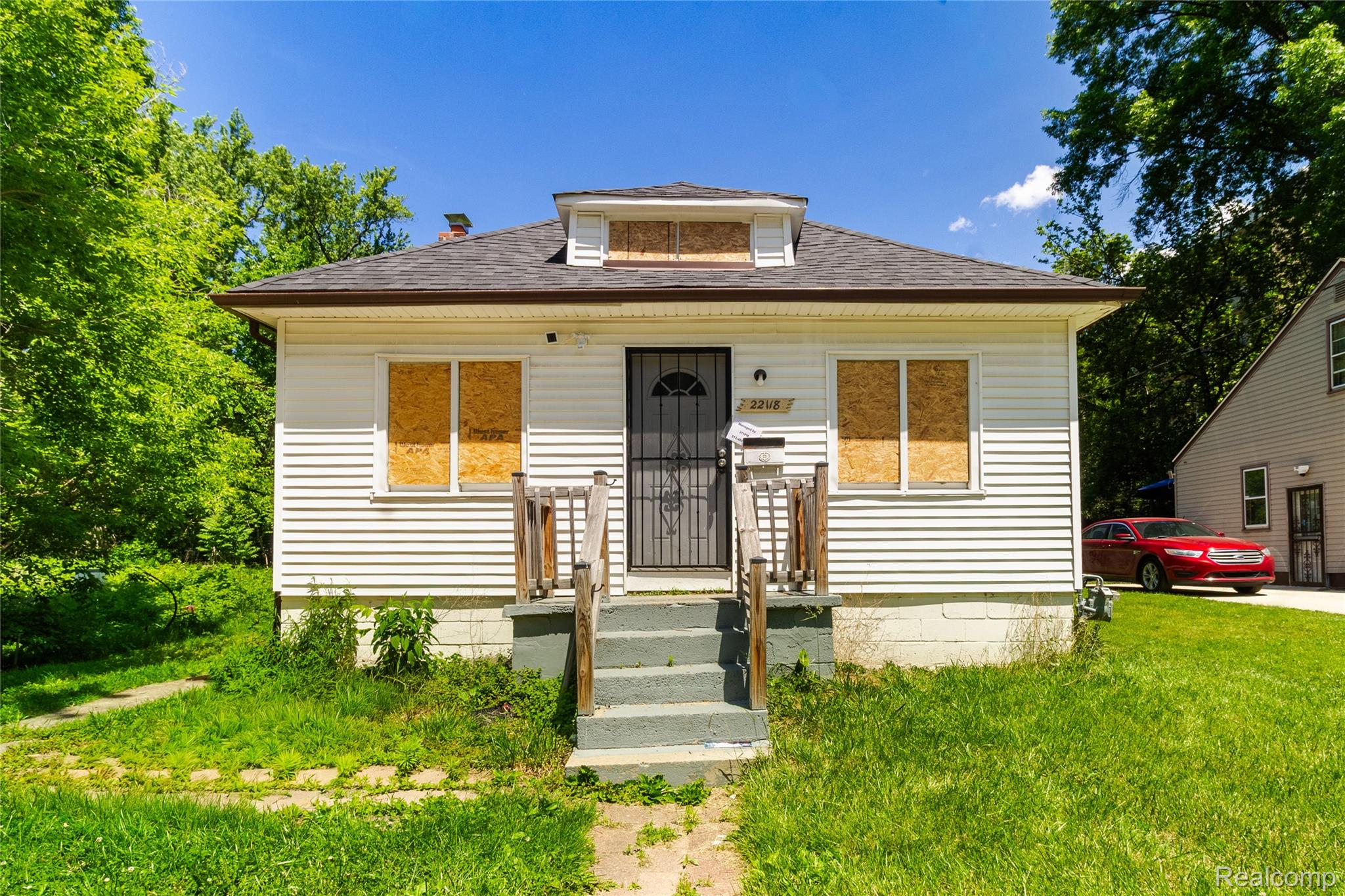 White siding exterior featuring a dark asphalt shingle roof