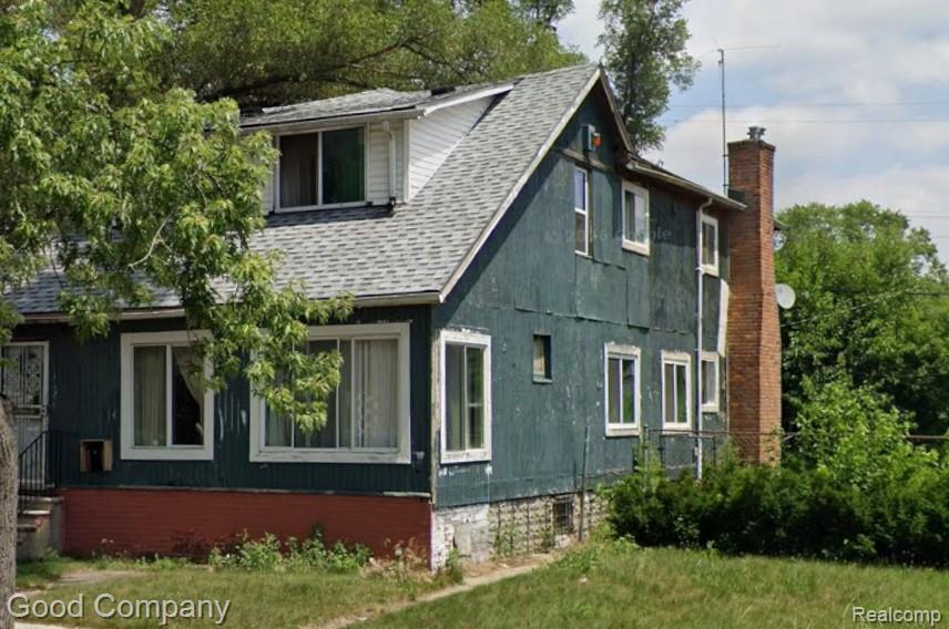 View of home's exterior featuring roof with shingles, a yard, and a chimney