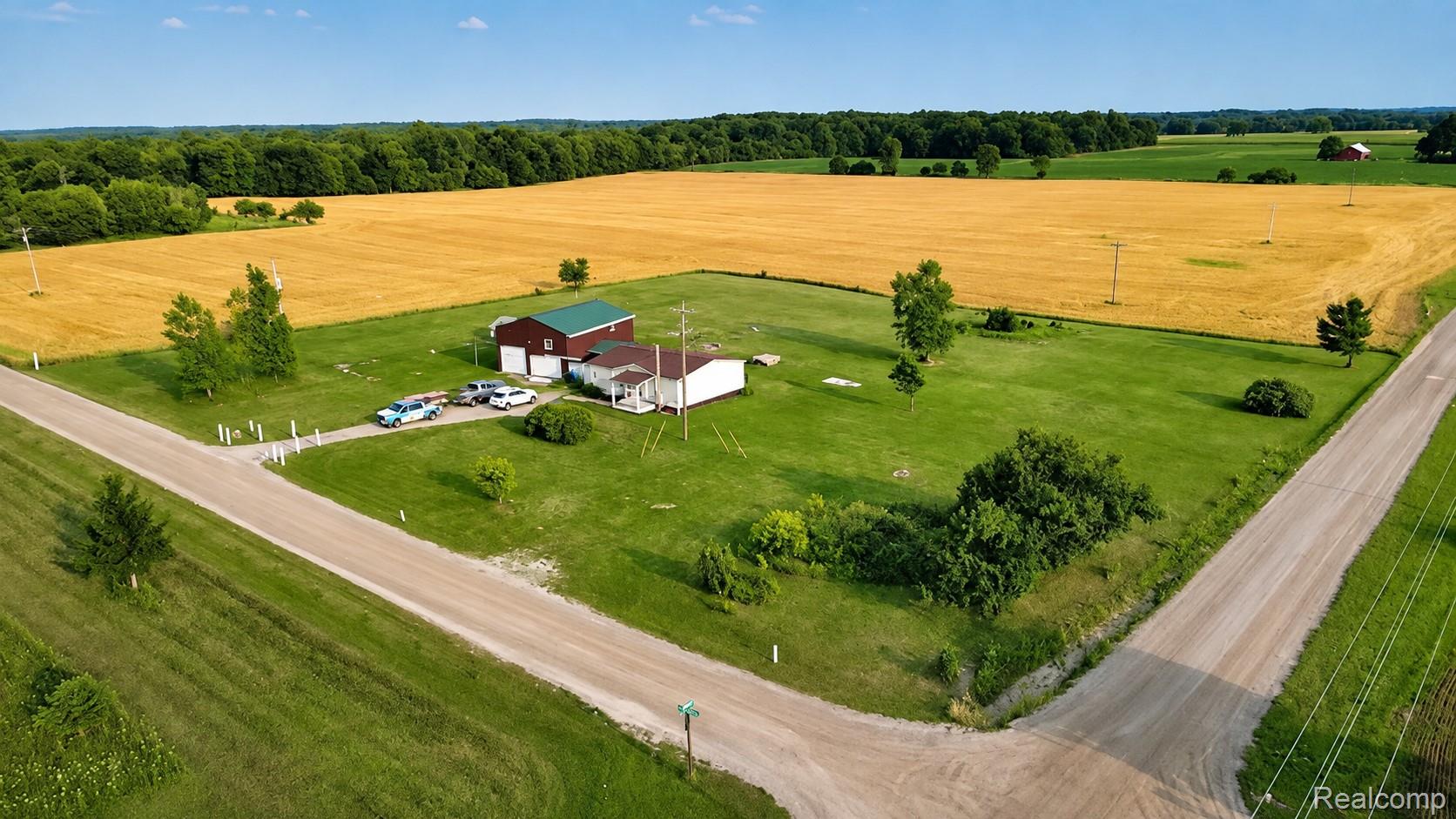 Single-story residence with a covered porch, detached barn, and expansive green lawn