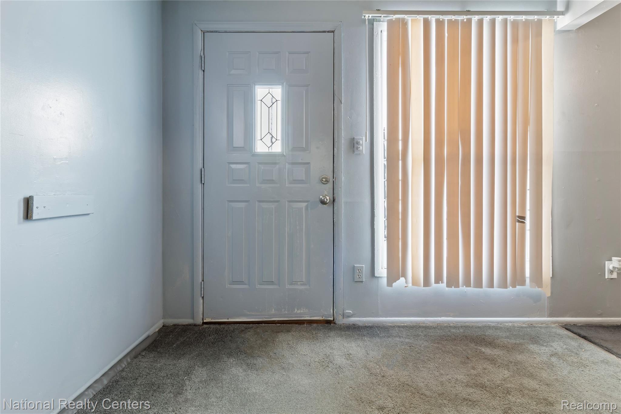 Foyer entrance featuring carpet floors and baseboards