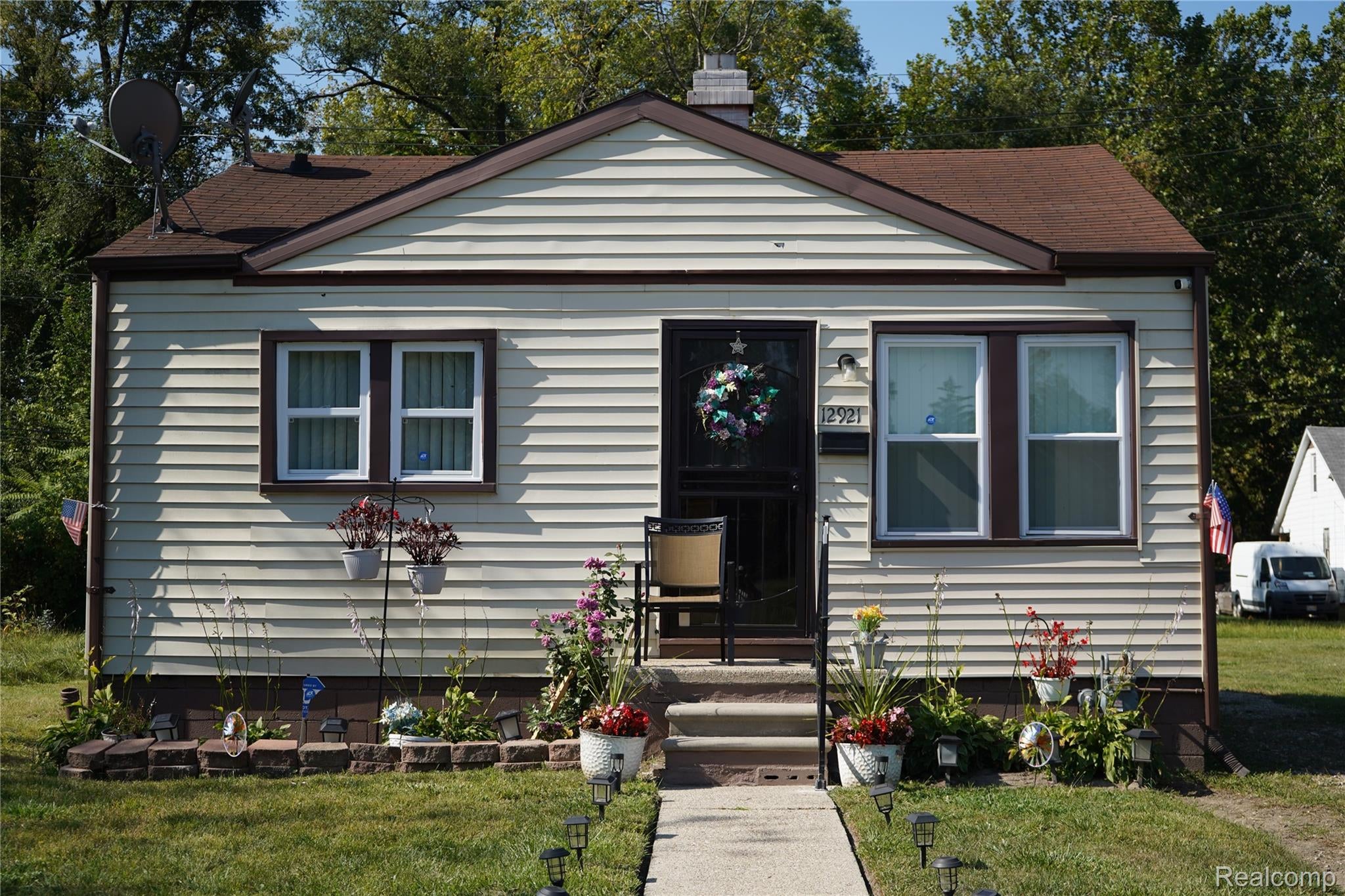 View of front of property with a front yard, a chimney, and roof with shingles