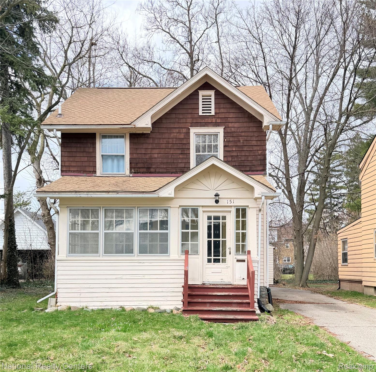 View of front of home featuring a front yard, entry steps, and a shingled roof