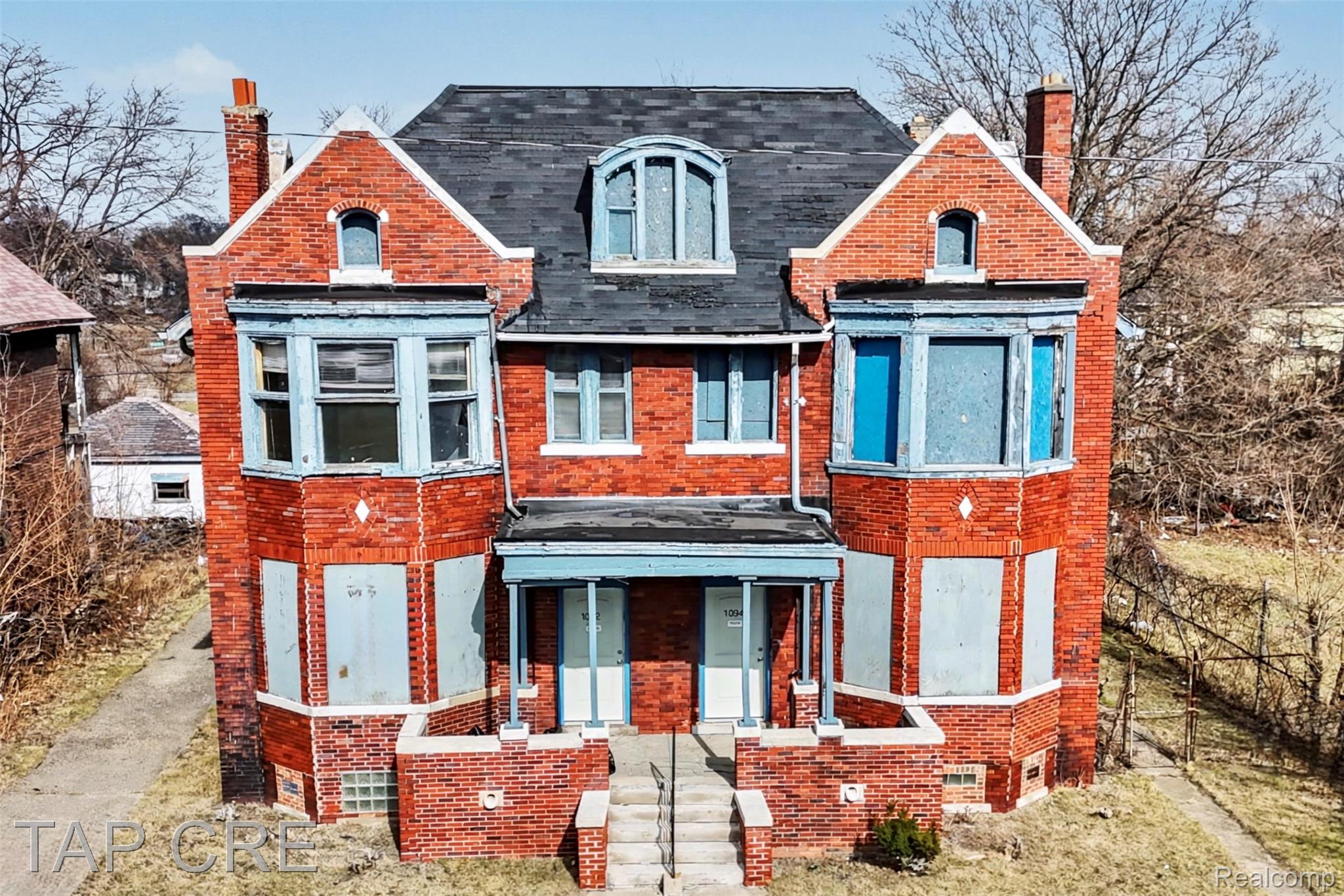 Two-story brick exterior with a dark-shingled roof