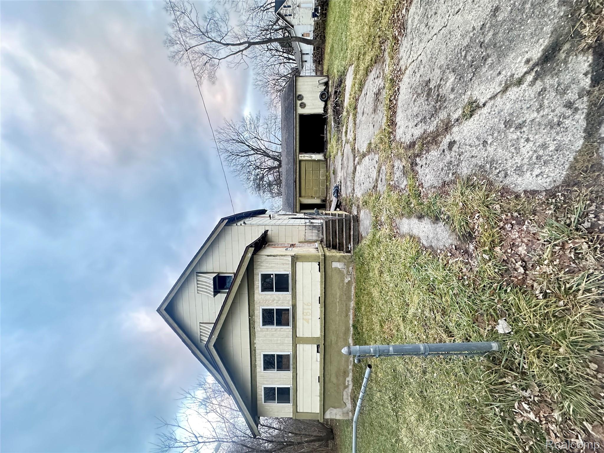 View of side of property featuring a yard and driveway