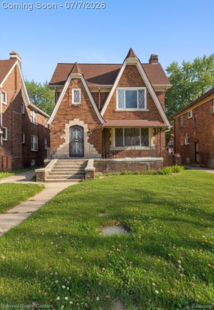 Brick exterior with a peaked roofline, front porch, and a concrete pathway leading to the entry