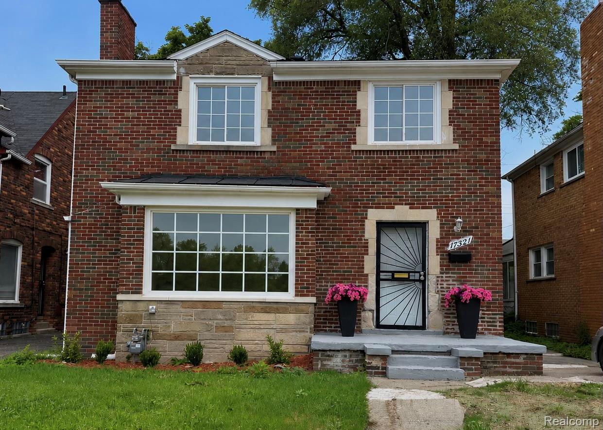 Brick exterior with stone accents and white window frames