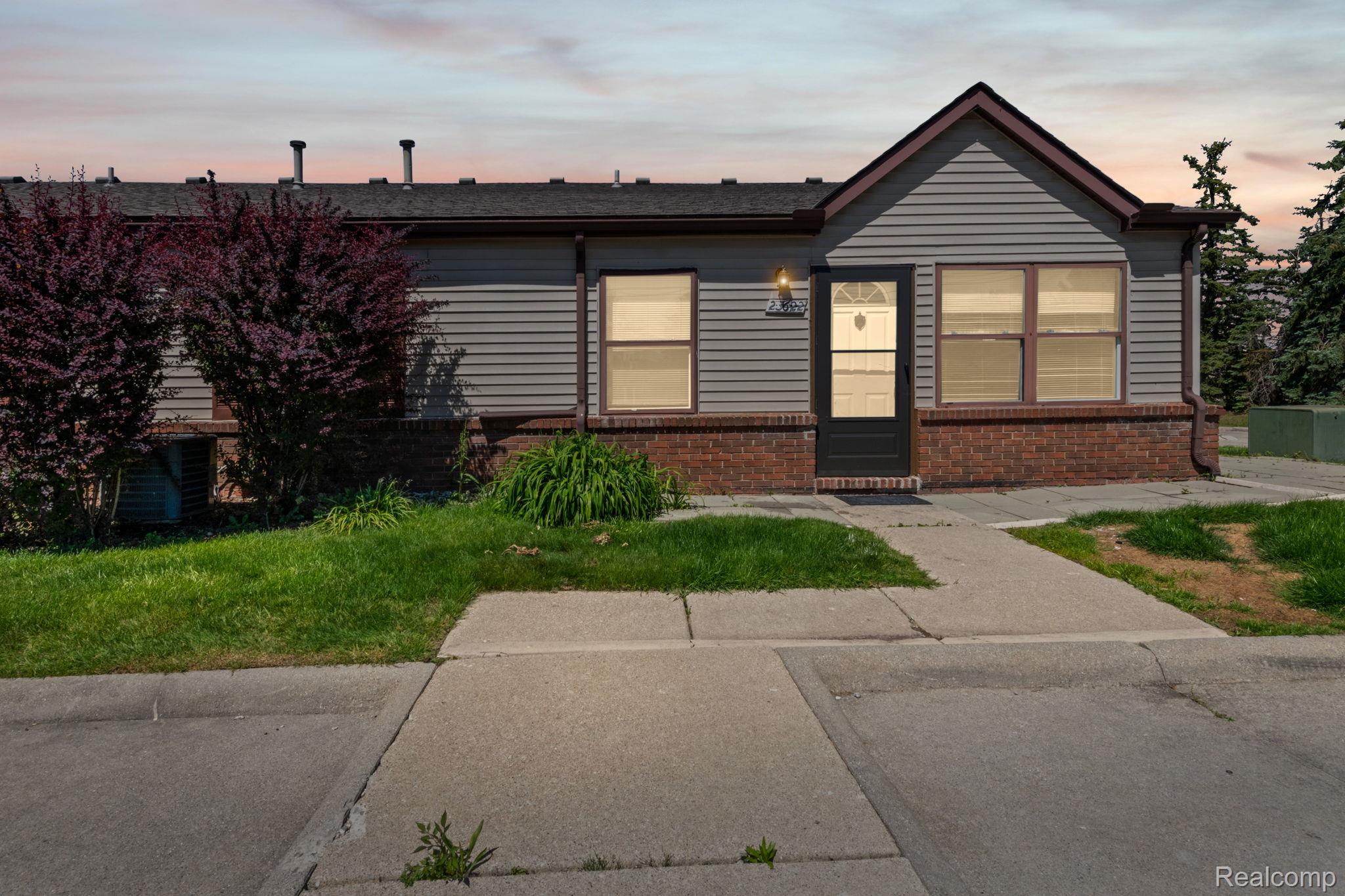 Single-story exterior with horizontal siding and a prominent brick foundation